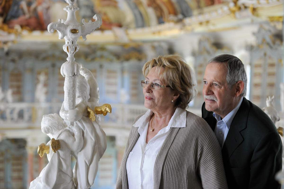 Besucher bestaunen die filigranen Figuren, die den Bibliothekssaal von Kloster Schussenried schmücken